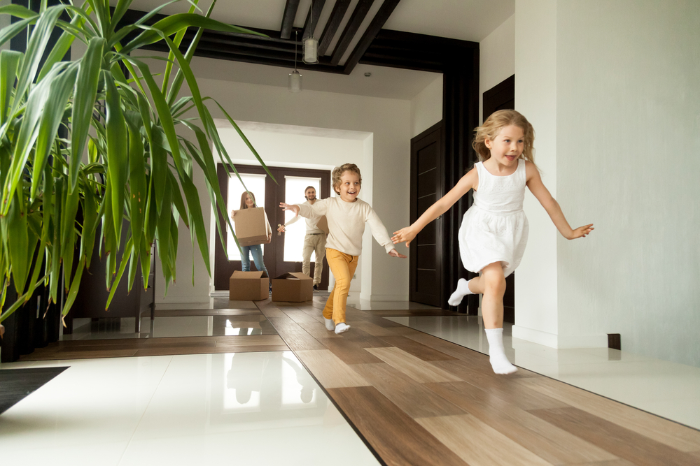 Happyyoungfamilywithcardboardboxesinnewhomeat How Do You Make A Move Easier For Kids